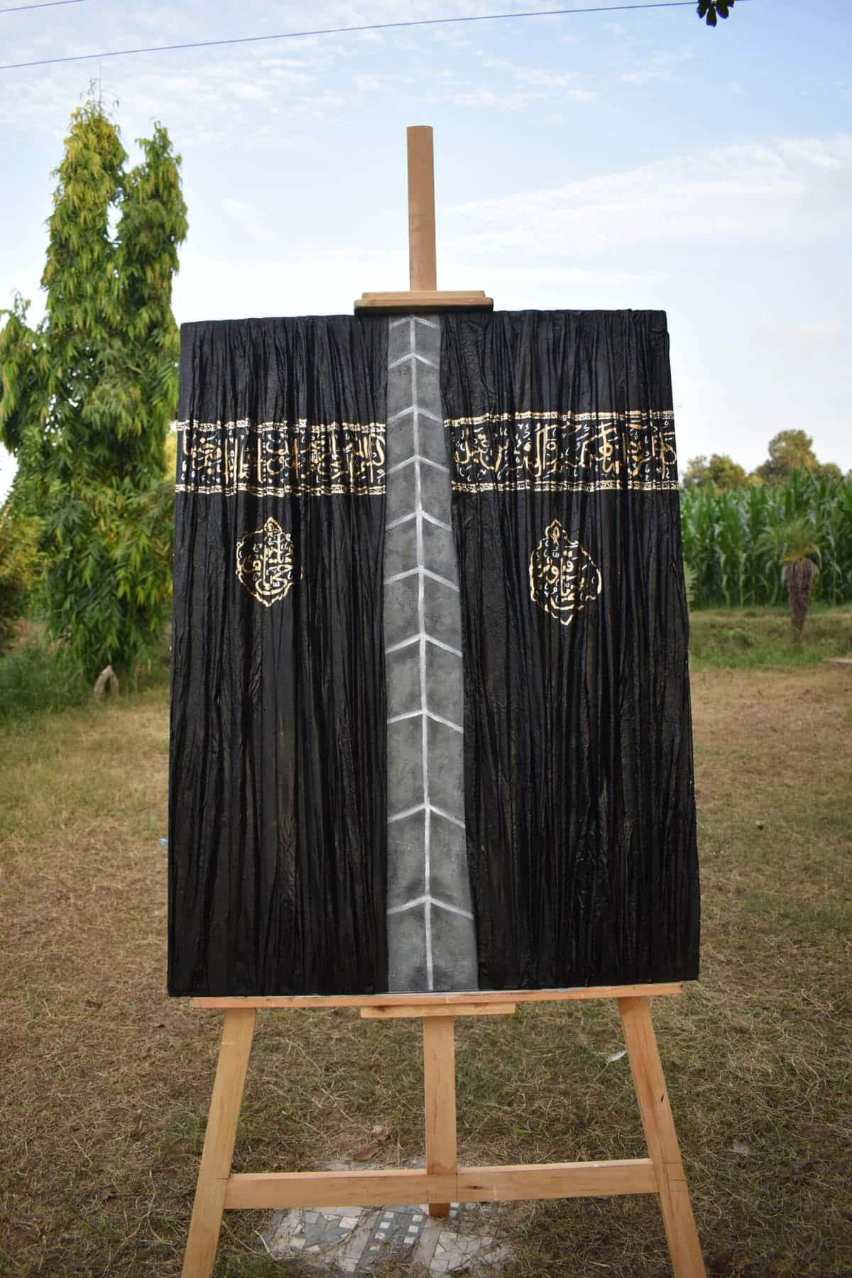 Kaaba Kiswah-inspired black and gold textured Islamic canvas with Arabic calligraphy and a central silver-grey design